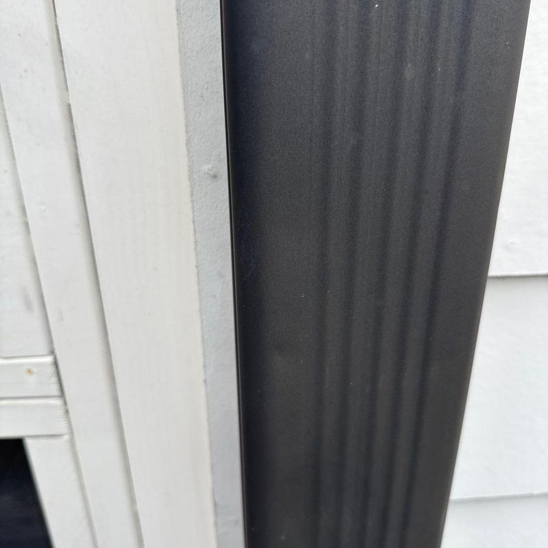 Downspout with minor dents and paint marks close-up