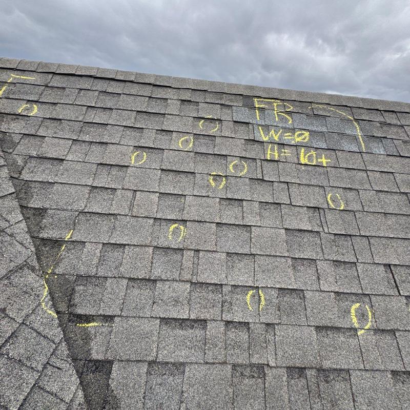 Asphalt shingles with hail impact markings on roof