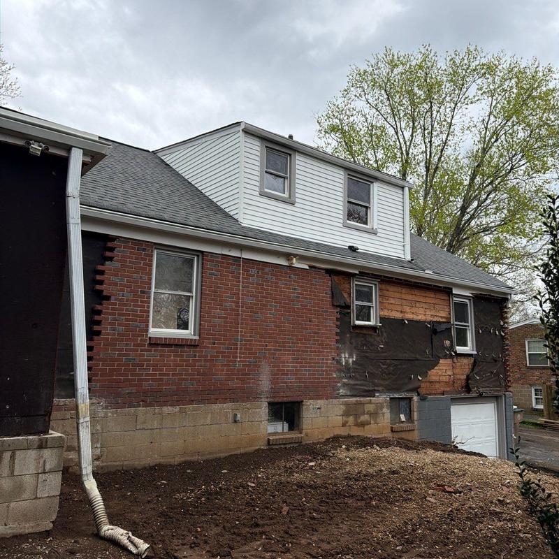Exterior brick siding with partial removal and weather barrier exposed