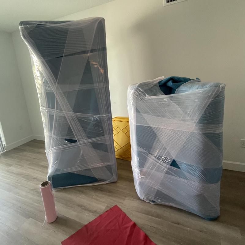 Wrapped furniture pieces secured for moving in apartment