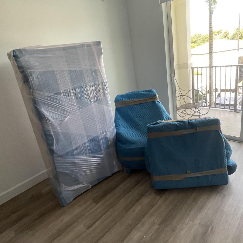 Wrapped mattress and chairs ready for moving in apartment