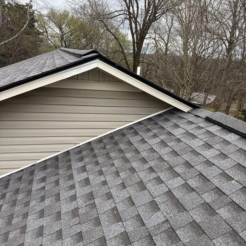 Asphalt shingle roof with hail damage on house roof edge