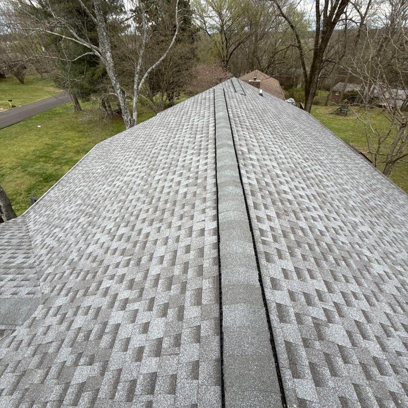 Architectural asphalt shingles with hail damage on roof ridge