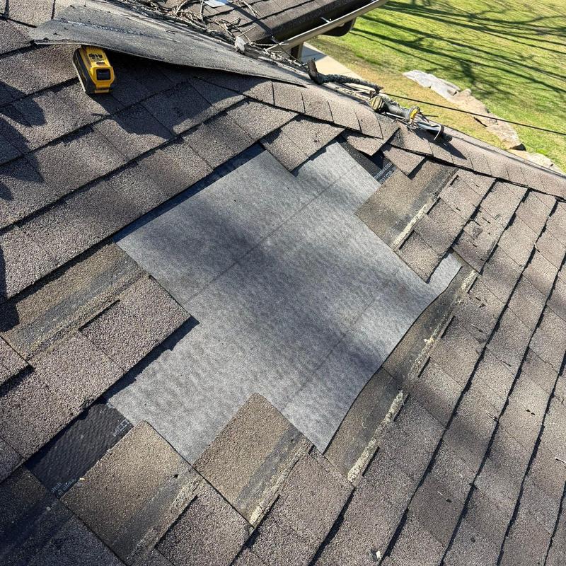 Roof shingles with hail damage and exposed underlayment
