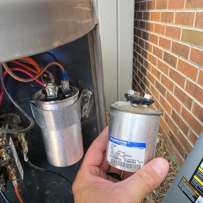 AC capacitor replacement with old and new capacitors visible AC capacitor replacement with old and new capacitors visible