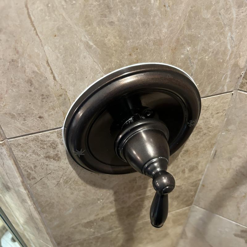 Shower valve handle on tiled wall in bathroom Shower valve handle on tiled wall in bathroom