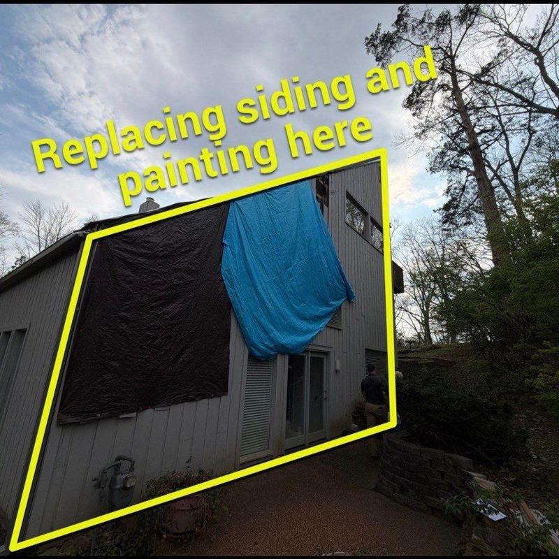 House siding covered with tarps for repair and painting