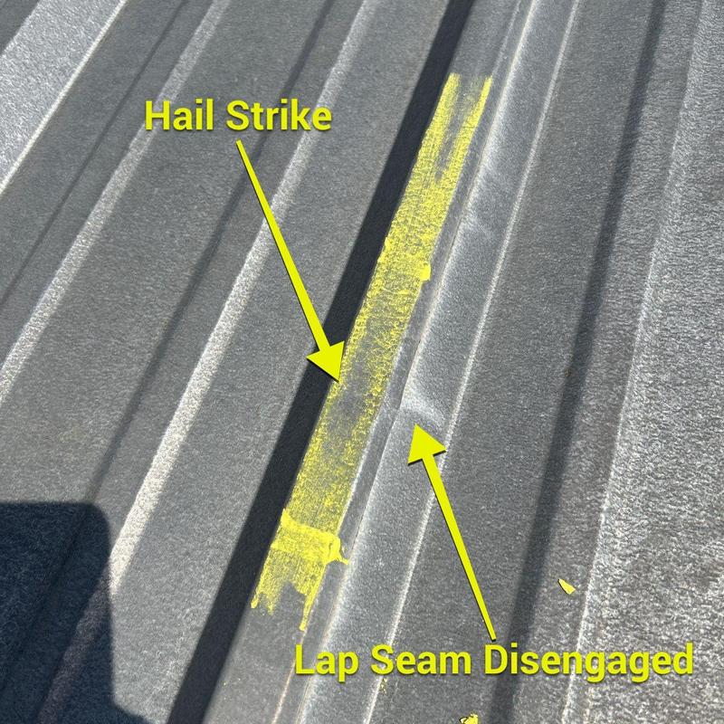 Metal roof panel with hail strike and lap seam damage