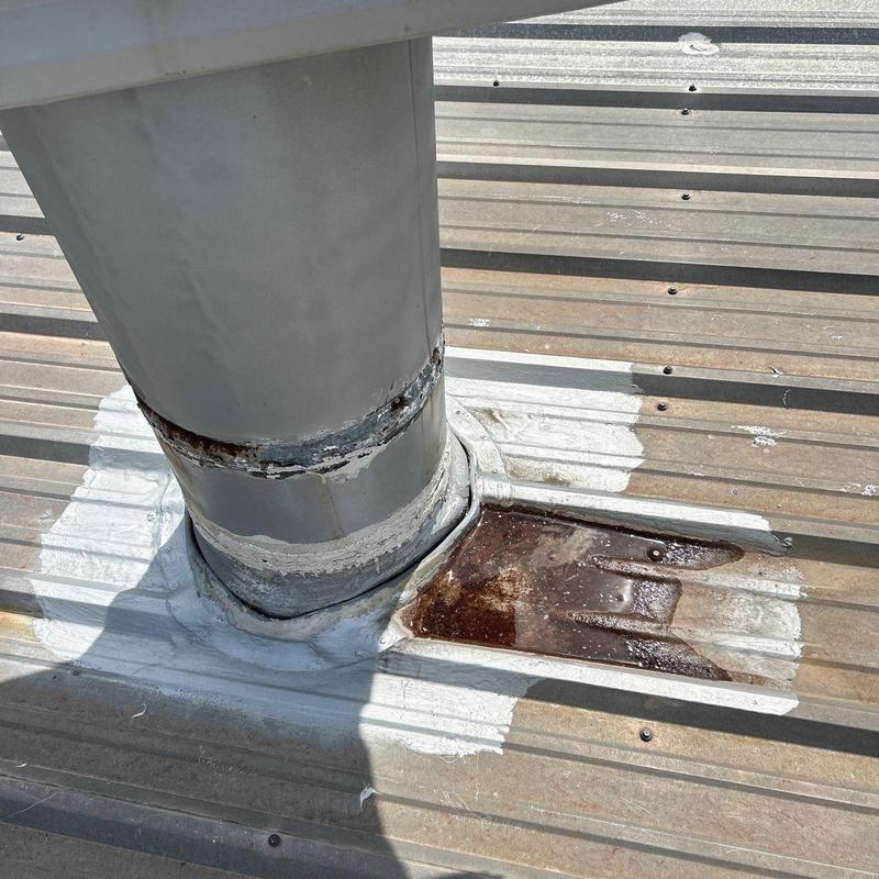 Metal roof vent flashing with rust and sealant damage
