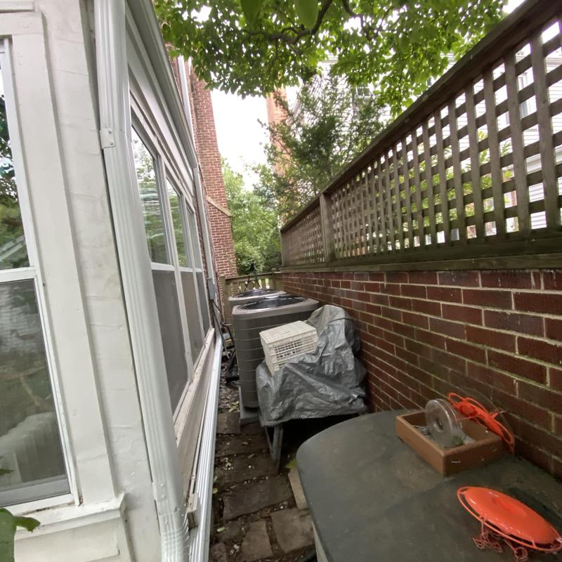 Gutter and downspout system along side brick wall
