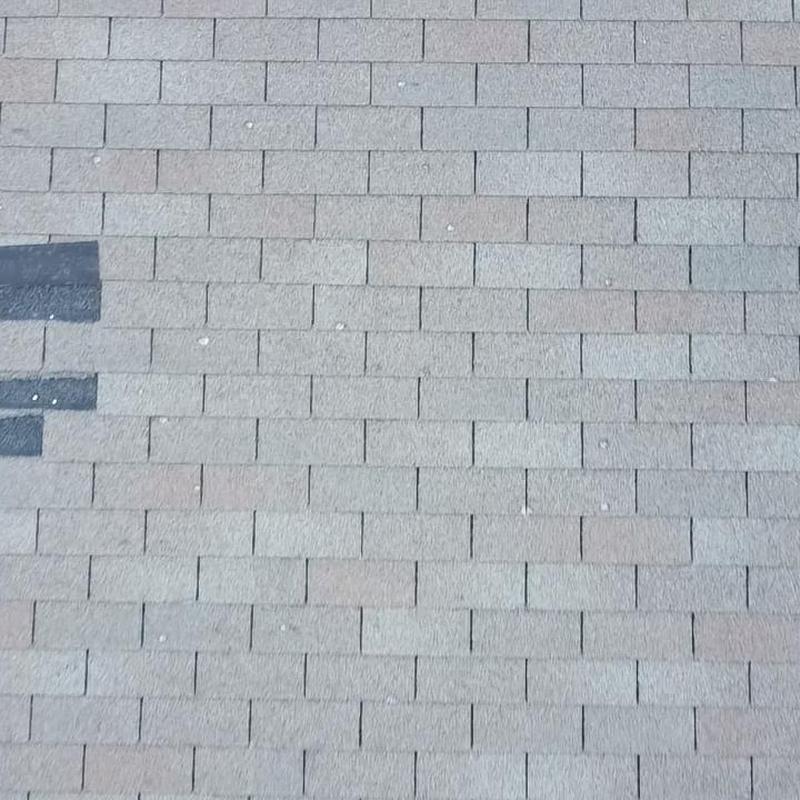 Asphalt shingle roof with hail impact marks inspection
