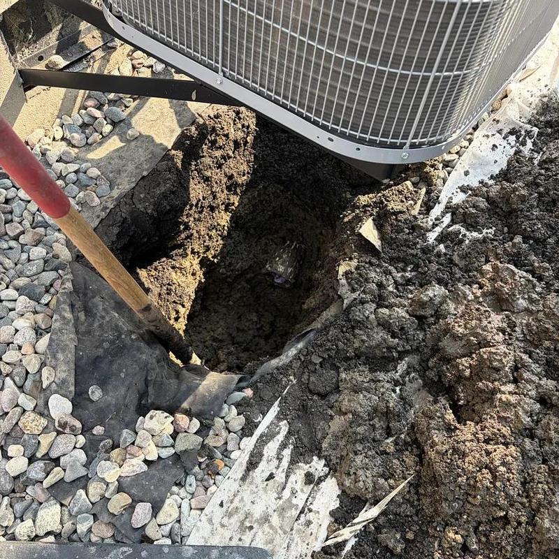 Sump pump discharge area with backfilled soil and hole
