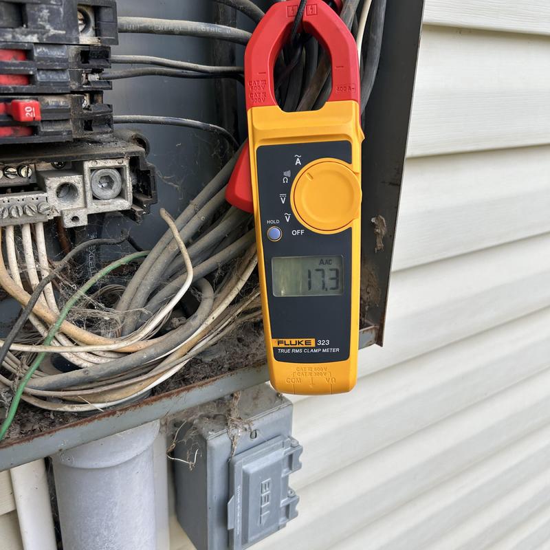 Clamp meter measuring current on electrical panel wiring Clamp meter measuring current on electrical panel wiring