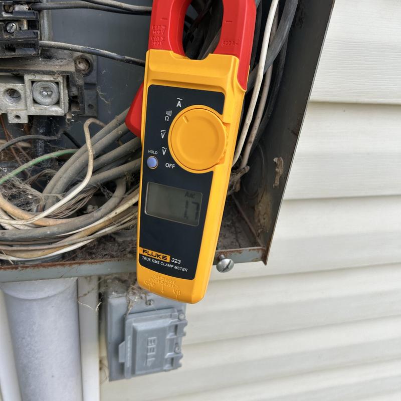 Clamp meter measuring current on electrical service panel wiring Clamp meter measuring current on electrical service panel wiring