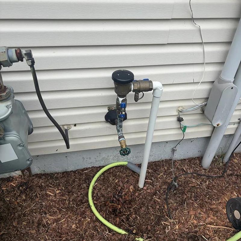 Ball valve and water meter setup on house exterior