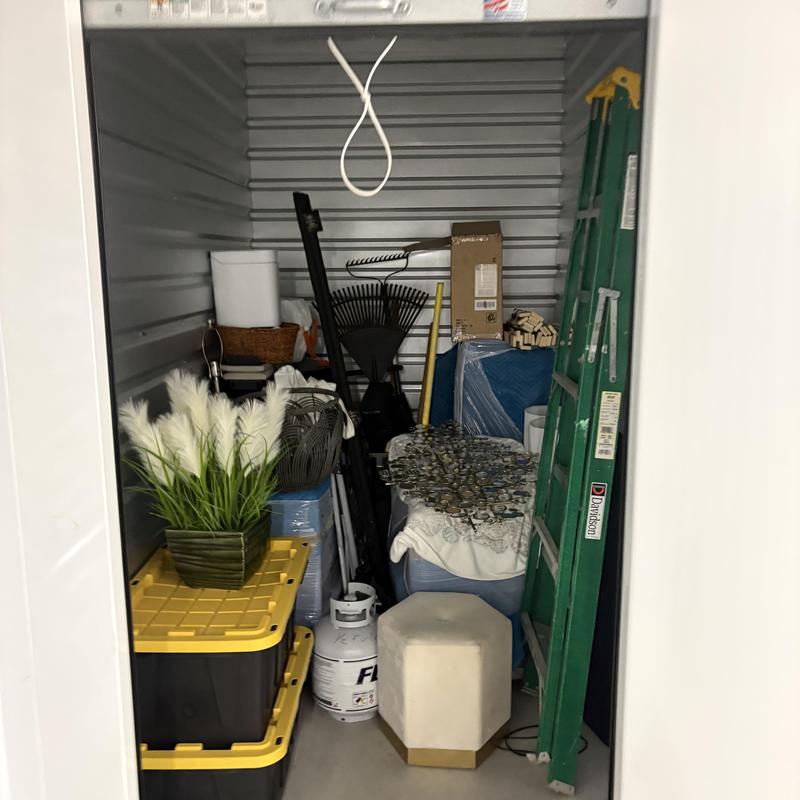 Storage unit with packed household items and ladder