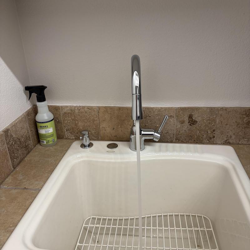 Faucet installation with flowing water in utility sink Faucet installation with flowing water in utility sink