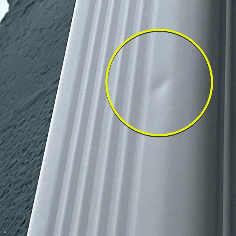 Metal roofing panel with hail damage dent highlighted