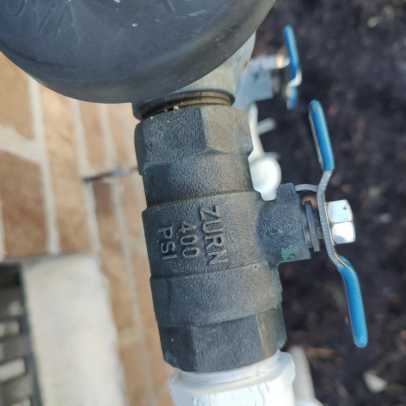 Backflow preventer valve with blue handles on piping Backflow preventer valve with blue handles on piping