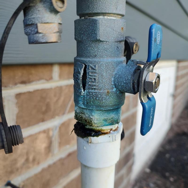 Backflow preventer valve with damaged casing outdoors Backflow preventer valve with damaged casing outdoors