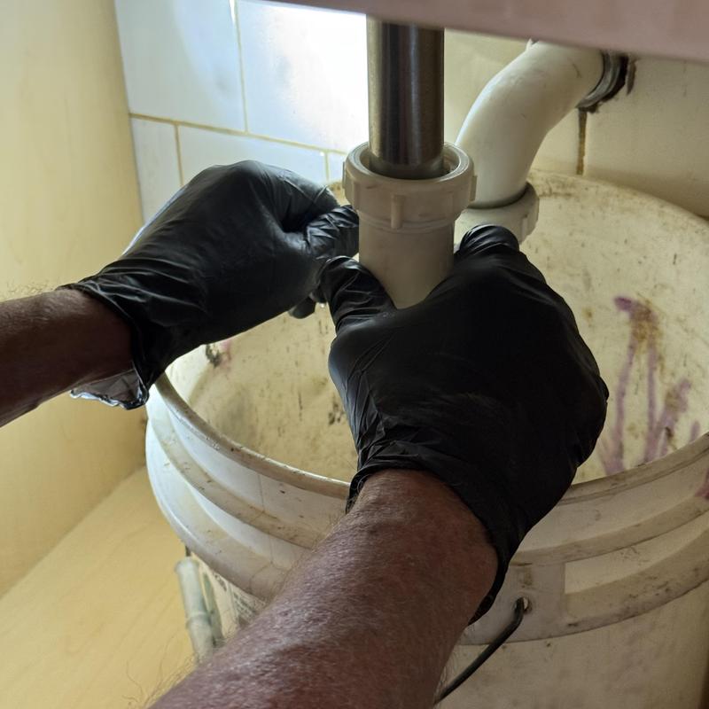 Lavatory sink drain pipe with plumber’s hands Lavatory sink drain pipe with plumber’s hands