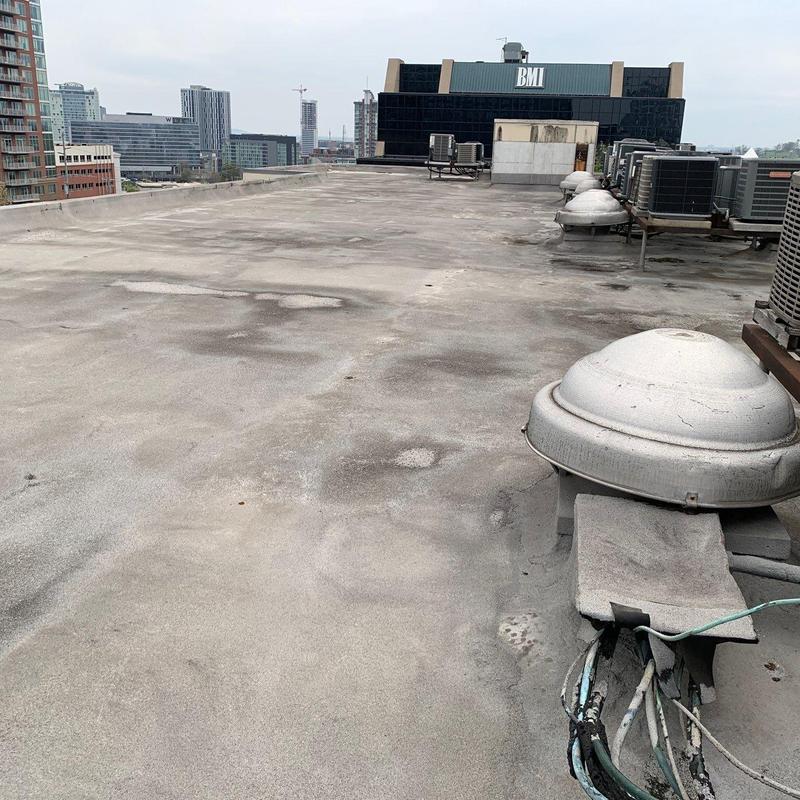 Commercial flat roof with hail damage and HVAC units