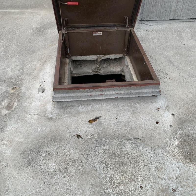 Roof hatch with damaged rooftop membrane and debris