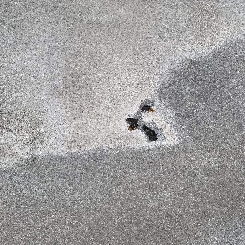 Commercial flat roof surface with hail damage holes