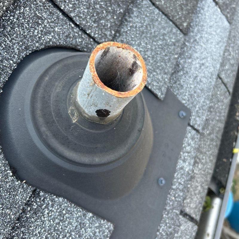 Roof vent pipe flashing on shingle roof with rusted pipe