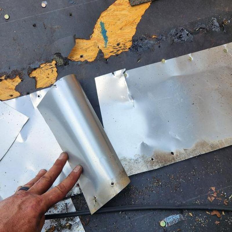 Metal step flashing pieces on low slope roof repair job