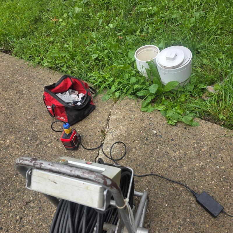 Sewer line inspection camera with equipment on driveway