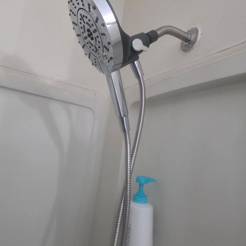Shower head with flexible hose in white shower stall
