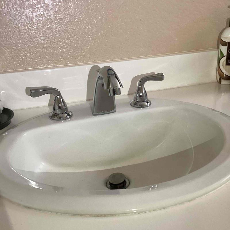 Bathroom faucet with chrome handles and sink basin