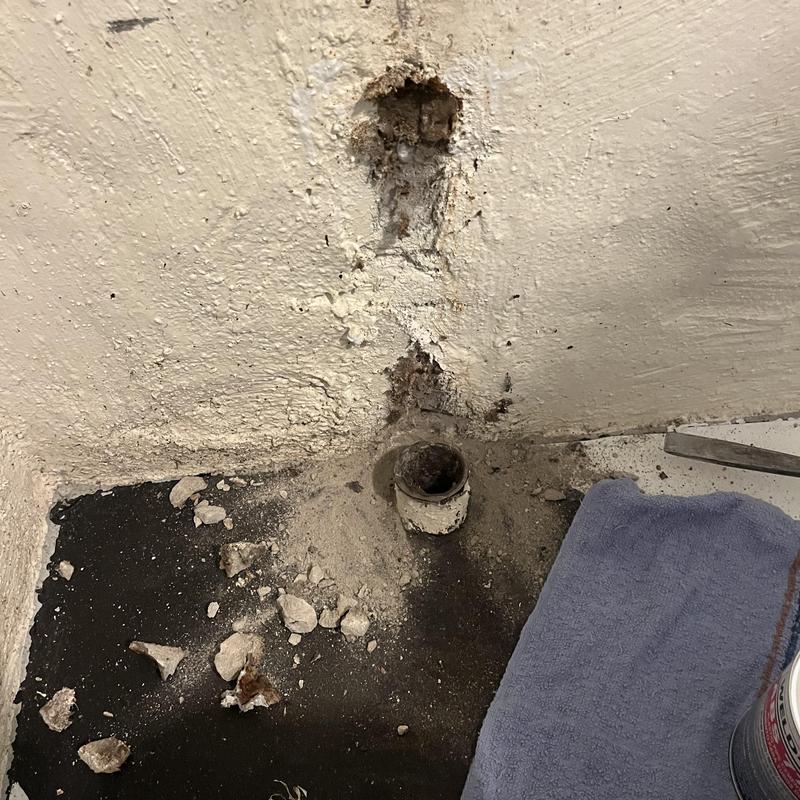 Cast iron pipe repair with wall and floor debris Cast iron pipe repair with wall and floor debris