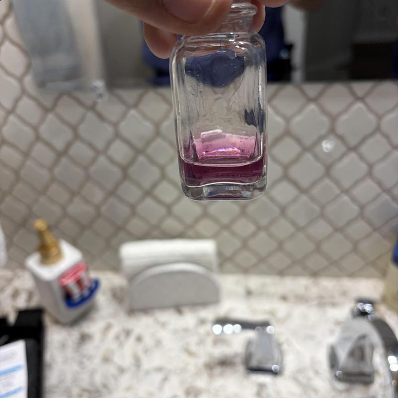 Water softener test sample with pink solution in bottle Water softener test sample with pink solution in bottle