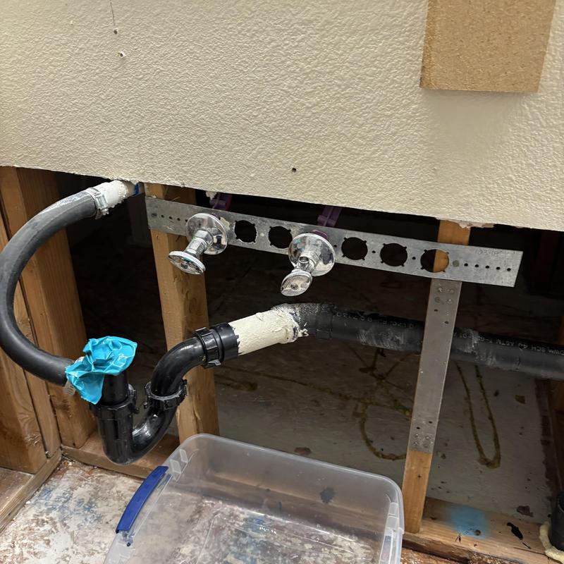 PVC drain piping with valve connections behind wall panel PVC drain piping with valve connections behind wall panel