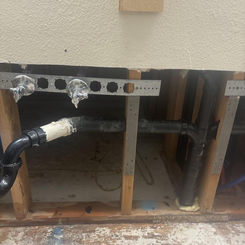 Black PVC drain pipes behind drywall during repair Black PVC drain pipes behind drywall during repair
