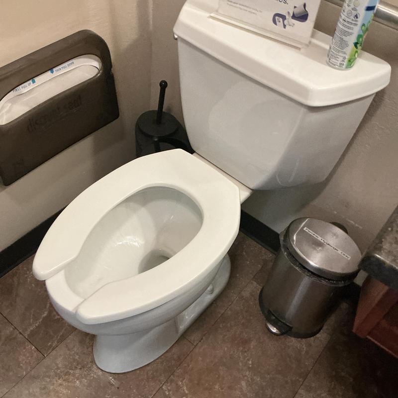 Toilet with open front seat in commercial restroom Toilet with open front seat in commercial restroom