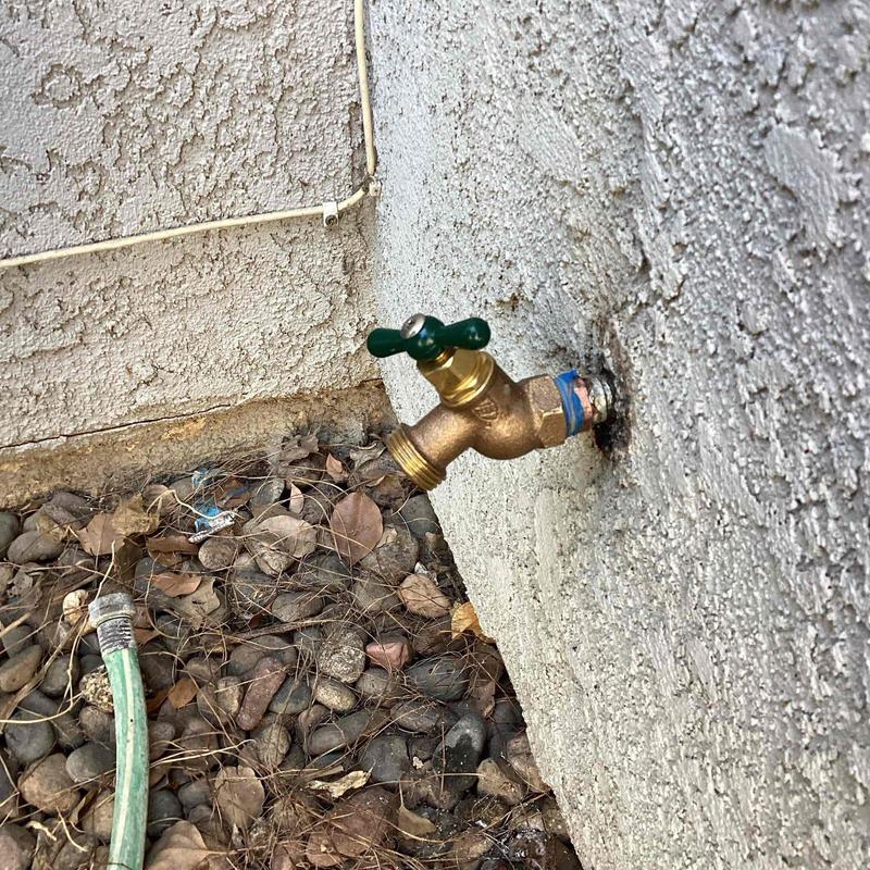 Brass hose bib installed on exterior wall