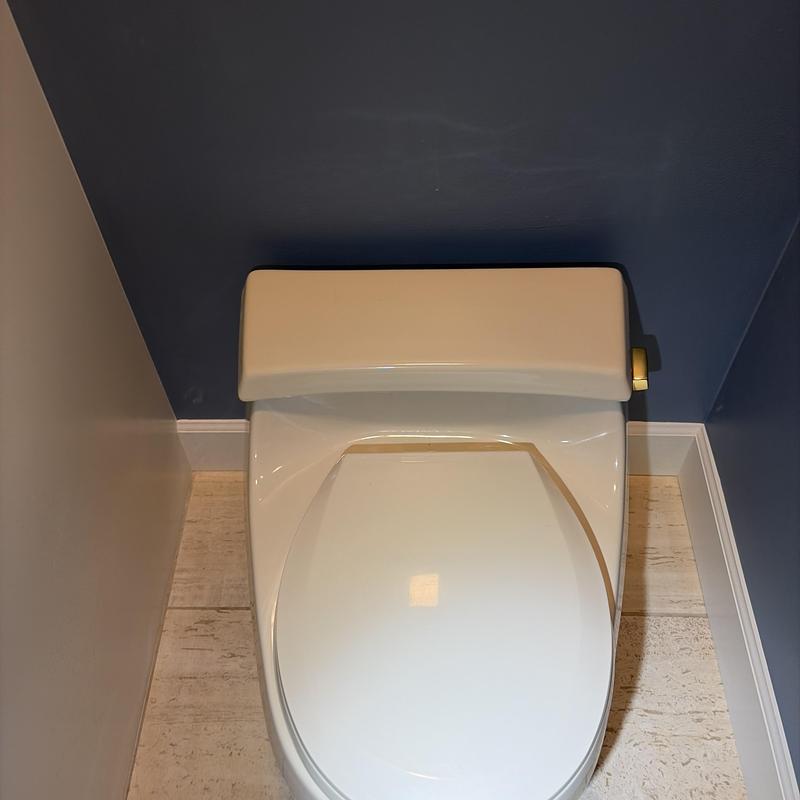 Toilet with closed lid in bathroom corner Toilet with closed lid in bathroom corner