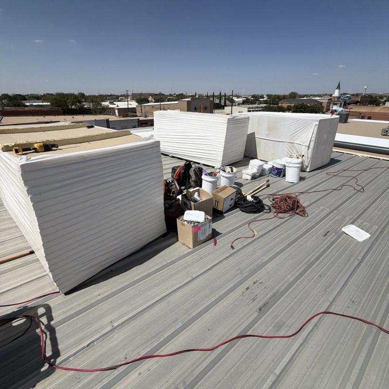 TPO roofing insulation panels and tools on metal roof