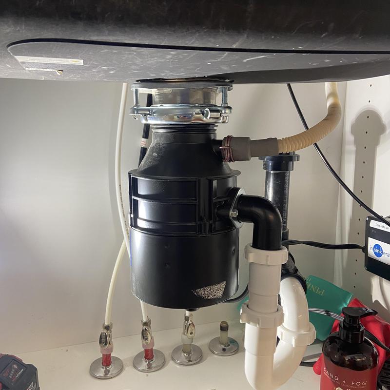 Garbage disposal with debris jam and leak under sink Garbage disposal with debris jam and leak under sink