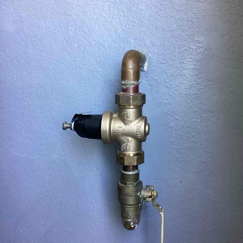 Pressure regulator valve with copper piping on wall
