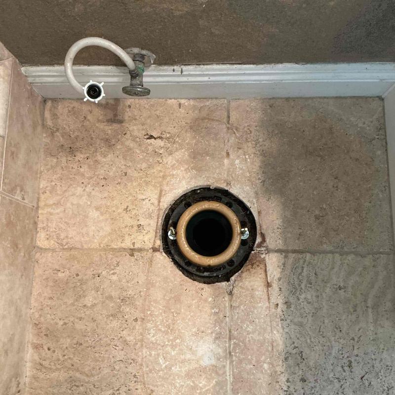 Toilet flange with new wax ring installed on tile floor