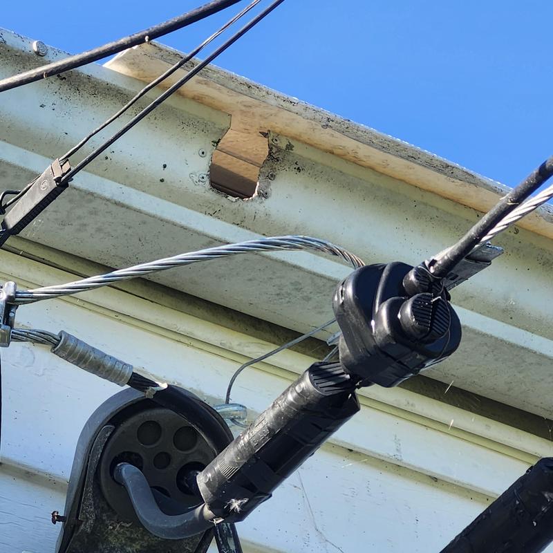 Gutter and fascia with hole and wiring on house exterior Gutter and fascia with hole and wiring on house exterior