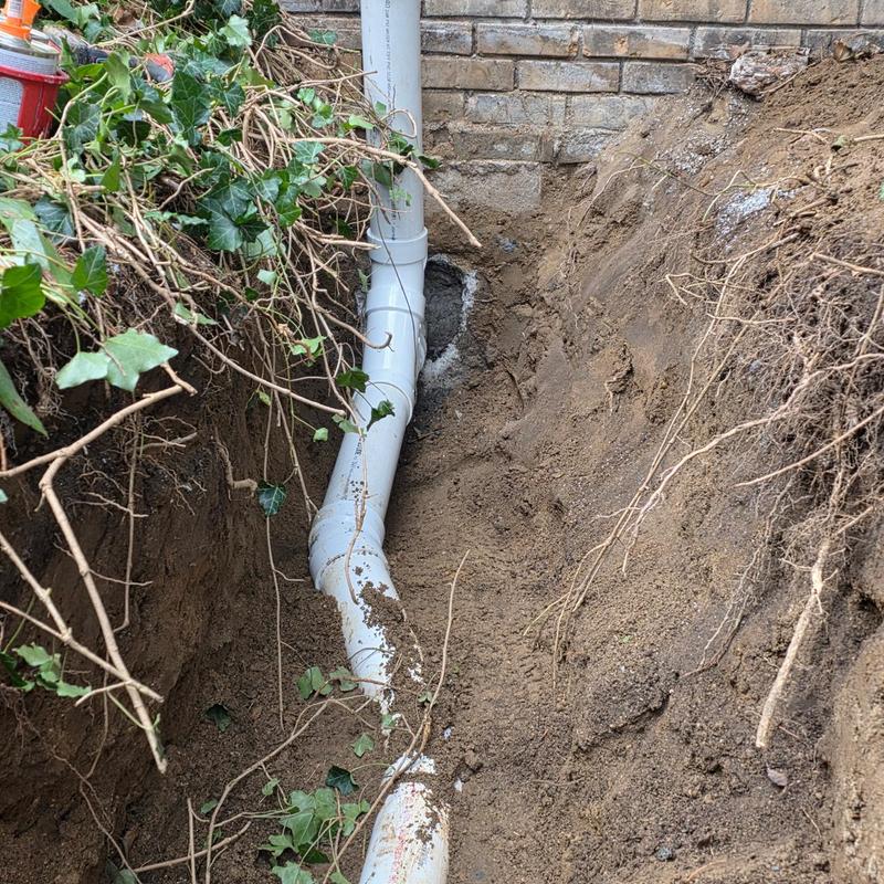 Septic line replacement digging near brick foundation