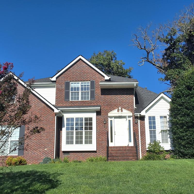 Roof shingles on brick home before metal roof replacement