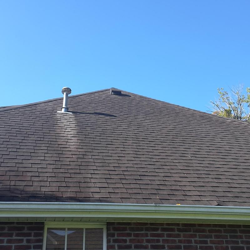Asphalt shingle roof with vent pipe under clear sky