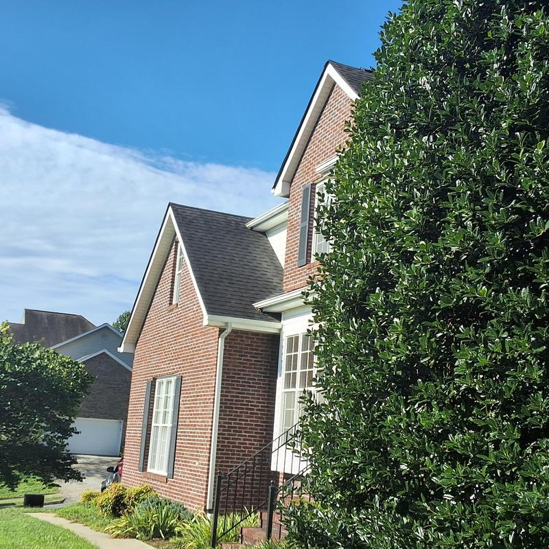 Roof shingles on brick home before metal roofing upgrade