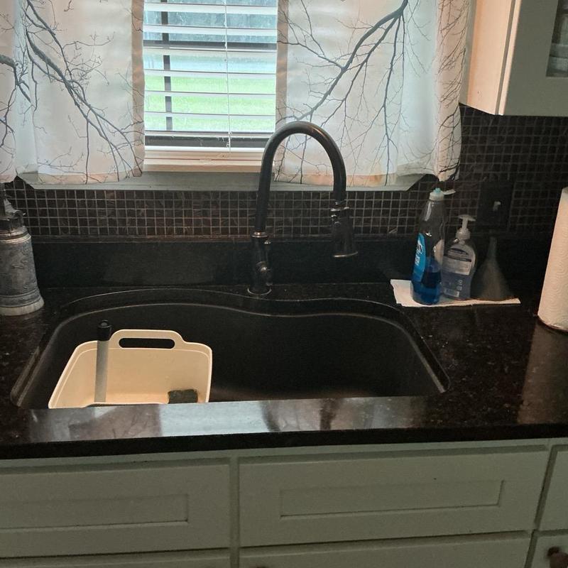 Kitchen sink with black faucet and soap bottles Kitchen sink with black faucet and soap bottles